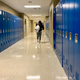 Student walking with backpack at school hall with blue lockers for back to school season.  - PhotoDune Item for Sale