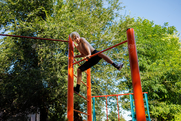 Street workout on a horizontal bar in the school park.