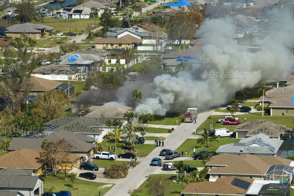 Aerial view of house on fire and firefighters extinguishing flames after short circuit