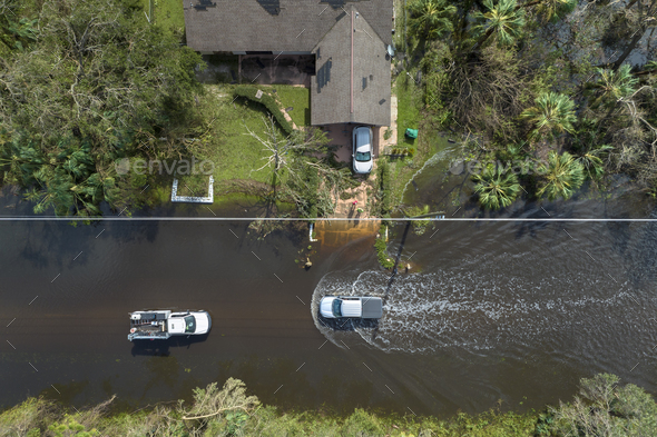 Hurricane Ian flooded street with moving cars and surrounded with water houses in Florida