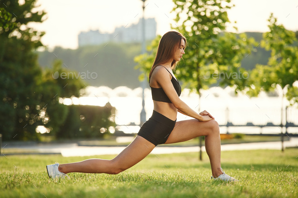 Doing sport. Young active fit woman with long legs listening to