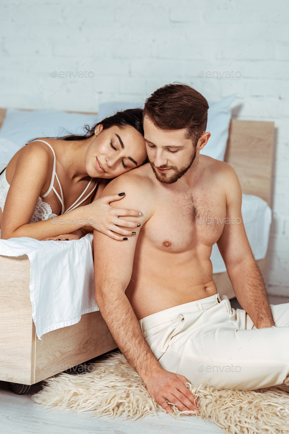 beautiful woman in lace bra kissing handsome man in bedroom Stock Photo by  LightFieldStudios