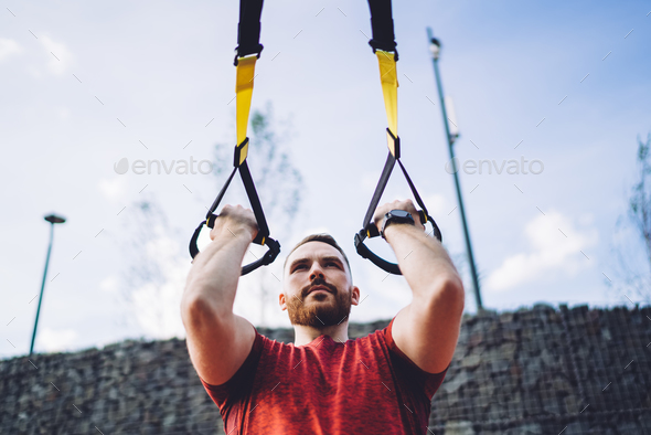 Determined man working out on TRX straps Stock Photo by GaudiLab