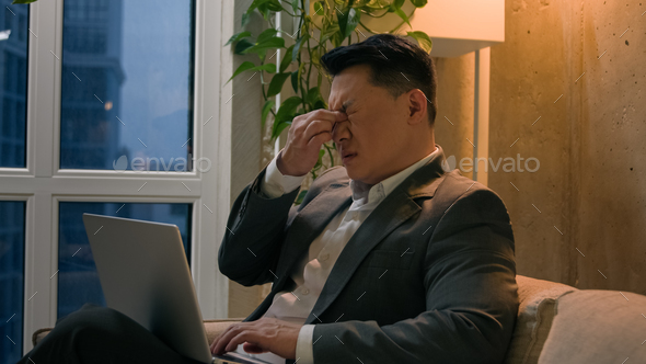 Sick Asian chinese korean male businessman tired exhausted man overworked late job with laptop in
