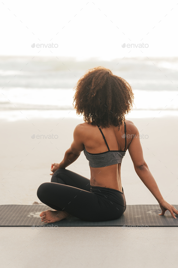 Young woman doing yoga poses at the the beach stock photo