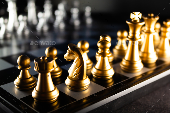 Horizontal shot of cool gold chess pieces in the starting position ...