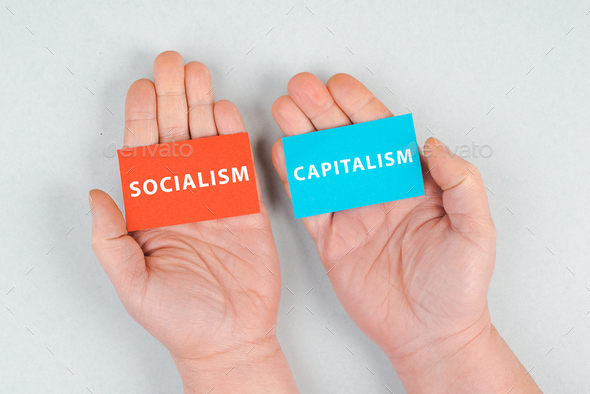 The words socialism and capitalism are standing on piece of papers, politics