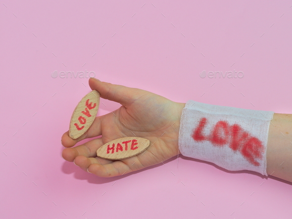 Man's hand holding the wooden boards with words LOVE and HATE with a ...