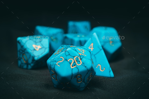 Closeup of turquoise dungeons and dragons dice on the green fabric