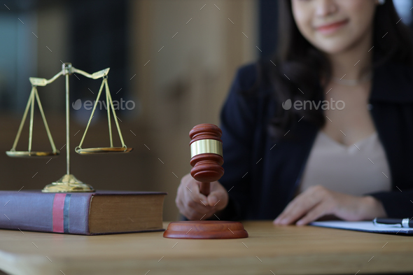 The female lawyer holds the mallet of justice and legal concepts.