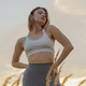 Female Fitness Trainer on the sand beach sunset background. Meditation and  harmony and balance Stock Photo by denismuse777