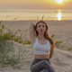 Female Fitness Trainer on the sand beach sunset background