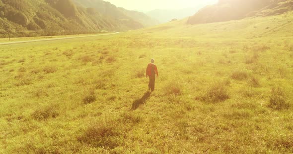 Flight Over Backpack Hiking Tourist Walking Across Green Mountain Field alt