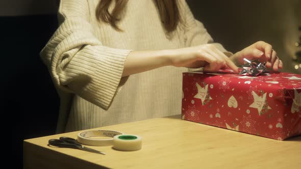 Girl Decorates Gift with Bow