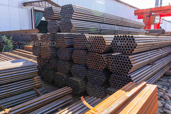 Galvanized iron pipes stack and steel rectangular bars of metal