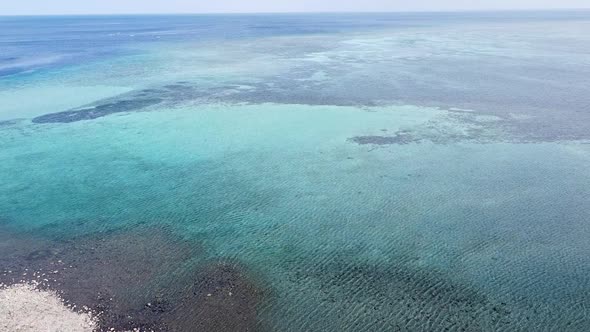 Aerial drone rising over beautiful crystal clear turquoise water and coral reef on coral triangle of alt