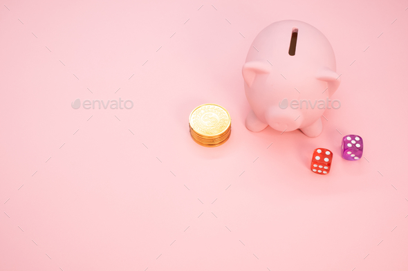 A piggy bank, dice and a stack of coins with copy space - gambling