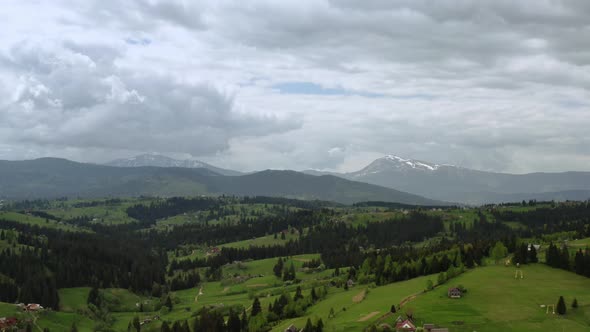 Aerial Drone Futage of Flying Up a Mountains Gren Pine Trees and Mountain Ranges in the Background alt