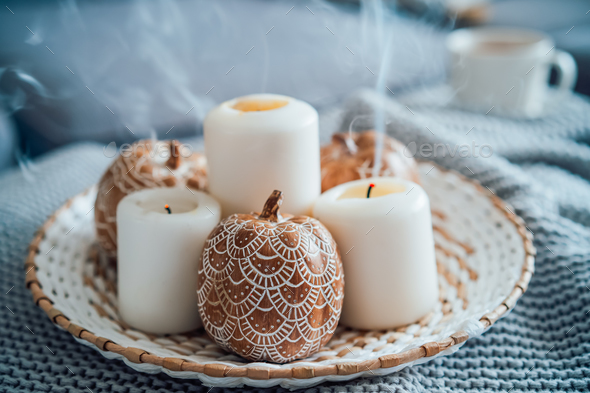 Autumn fall cozy mood composition for hygge home decor. Orange pumpkins decorated with mandalas