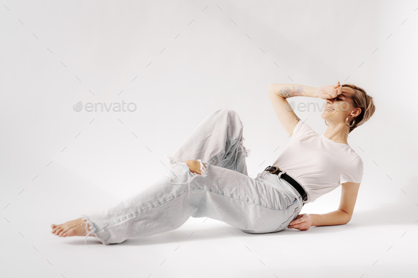 Young Woman in Casual Clothes Lying on Floor in Relaxed Pose