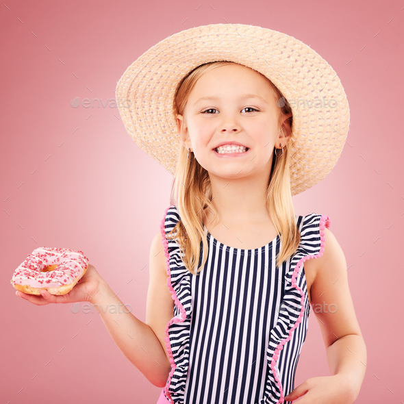 Happy, portrait and girl with a donut or child with sugar, dessert and sweet craving on pink backgr
