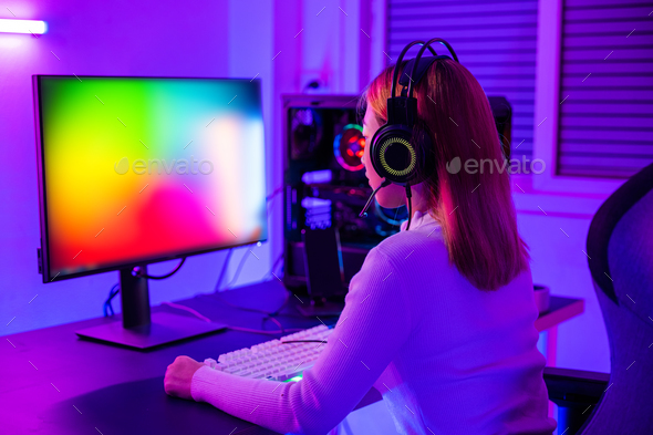 Asian professional gamer playing online video game on desktop computer PC have colorful neon LED