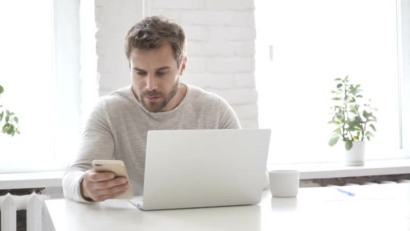 Businessman Working on Laptop and Smartphone in Office alt