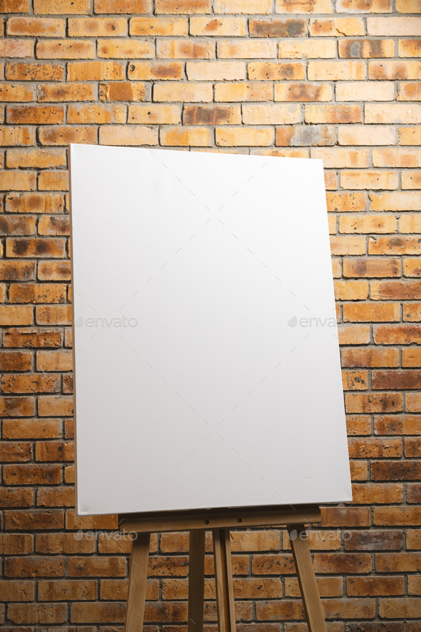 Wooden easel with blank canvas on white background