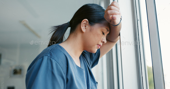 Healthcare nurse, stress and headache by window for working burnout, frustrated employee and tired