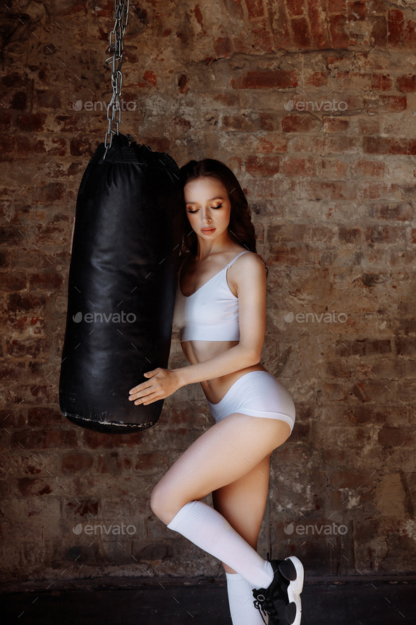 Sexy woman on the background of a punching bag