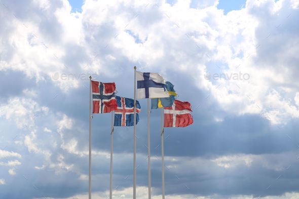 Closeup of the Norway, Iceland, Finland, Denmark, Sweden flags waving in the air against a blue sky