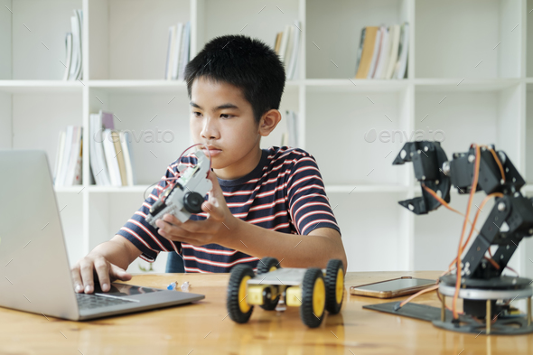 Asian teenager doing robot project in science classroom. technology of ...