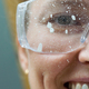 Close up of a smiling woman face wearing protective glasses covered in paint - PhotoDune Item for Sale