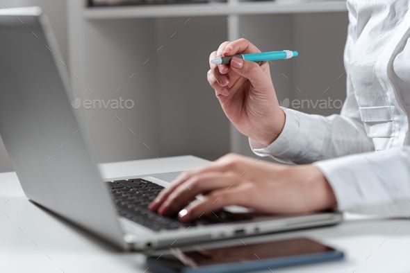 Woman Typing Updates On Lap Top And Pointing New Ideas With Pen.
