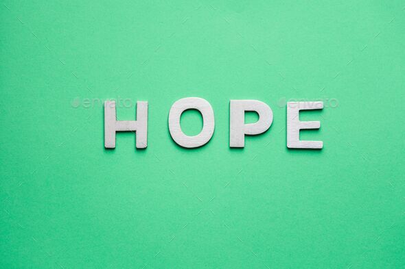 Tope view of wooden letters on the green backgrounds writing the word hope with capital letters
