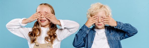 panoramic shot of smiling kids obscuring faces isolated on blue
