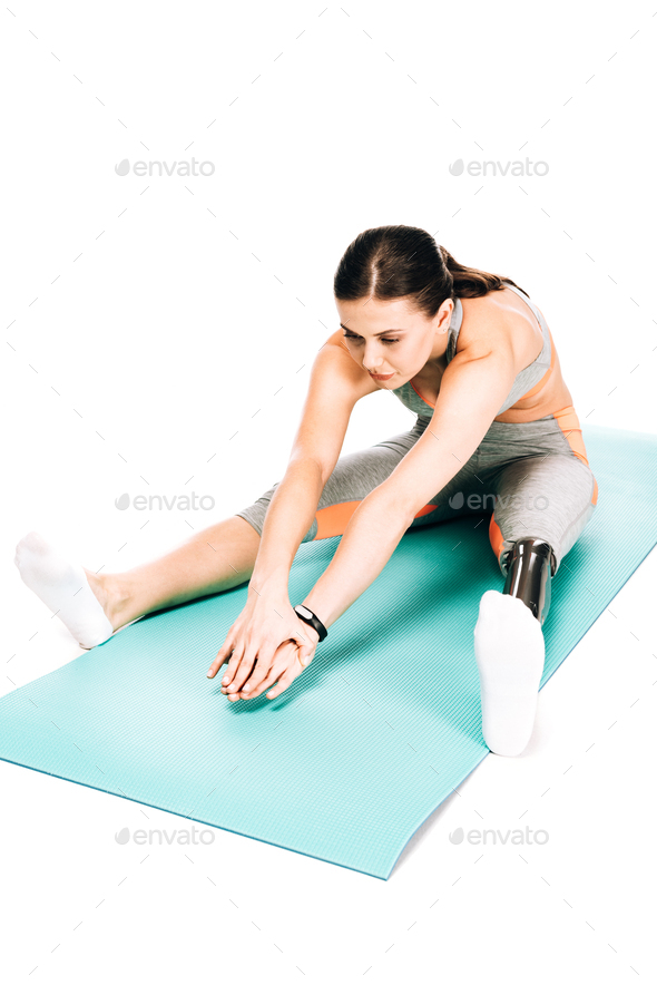 overhead view of disabled sportswoman stretching on fitness mat isolated on white