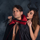 attractive woman with horns holding flogging whip near man in vampire  halloween costume on black Stock Photo by LightFieldStudios
