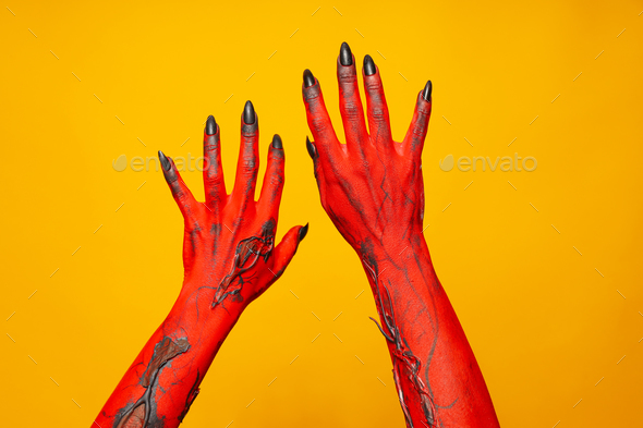 Creepy, red hands of a monster on a yellow background