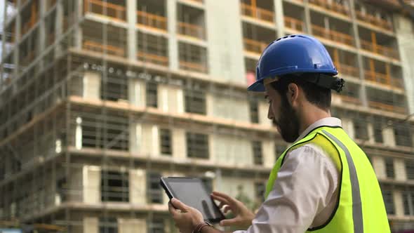 Man taking picture with digital tablet at construction site