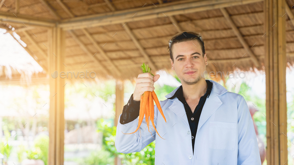 Agricultural researchers hold and analyze research carrots to produce better results in the future.