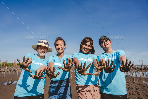 A Volunteer group of people are smiling and showing hands in the park.