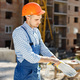 Worker in orange helmet at a construction site wearing gloves - PhotoDune Item for Sale