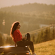 Young woman relaxing on a terrain vehicle hood at countryside - PhotoDune Item for Sale