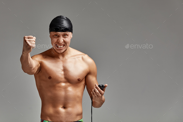 Excited swimer with stopwatch standing on gray background. New record. Motivation, advertising