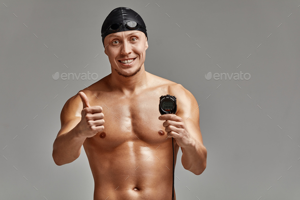 Excited swimer with stopwatch standing on gray background. New record. Motivation, advertising
