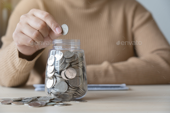 Woman with bills and savings coin jar to pay monthly