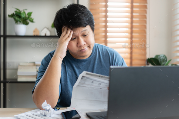 Asian sad and worried man going crazy with bill payment amount