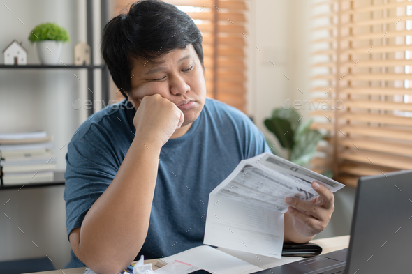 Asian sad and worried man going crazy with bill payment amount