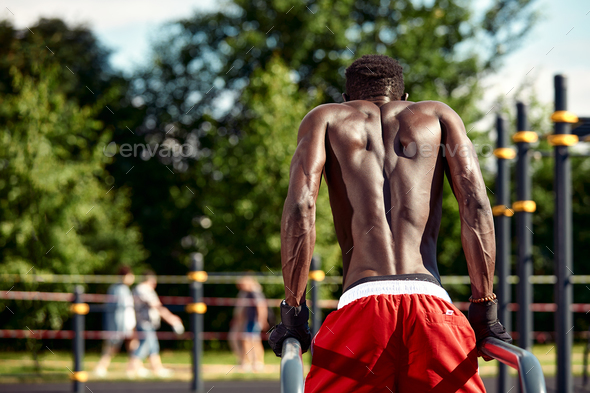 Foto de Naked shirtless fitness man doing push ups - muscular abs do Stock